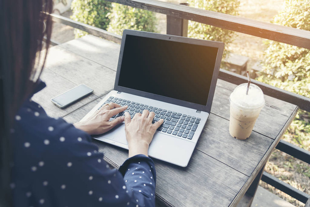 Вид сбоку на молодую умную женщину с ноутбуком с солнечным светом. Работа в любом месте в любое время
. - Фото, изображение