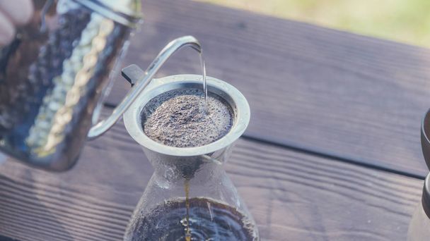 Handtropfkaffeemaschine übergießen Kaffee mit heißem Wasser aus einem Wasserkocher mit Blick auf die Berge und natürliche grüne Aussicht Gefühl Chillen und Entspannen in der Natur gegossen - Foto, Bild