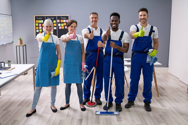 Portrait Of Happy Diverse Janitors In The Office With Cleaning Equipment Showing Thumb Up Sign - Foto, immagini