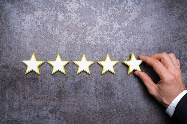 Person's Hand Making Five Star Rating Icon On Desk - Photo, Image
