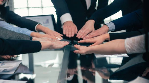 business team joining them in the palm of your hand above the Desk. - Fotoğraf, Görsel