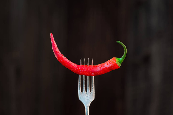 Fresh red chilli pepper on a fork - Fotó, kép