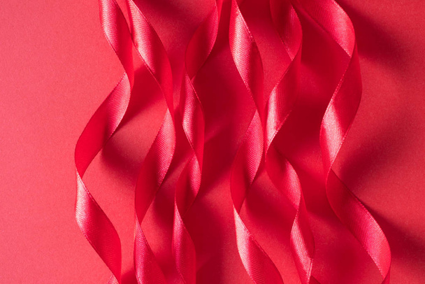 Bright pink color curl satin ribbon on paper background. Minimal - Foto, afbeelding