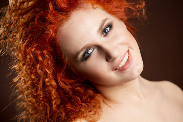 Uzun ve parlak dalgalı kızıl saçlı kız. Kıvırcık saçlı güzel bir manken. - Fotoğraf, Görsel