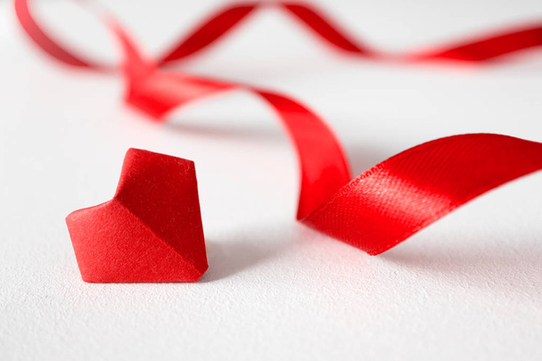 Origami hart en satijnen banden op witte achtergrond in vooraanzicht. - Foto, afbeelding