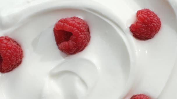 closeup of rotating yogurt with raspberries, top view - Záběry, video