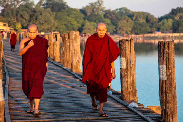 Мандалай, Мьянма - Ноя 12, 2019: Монахи у моста У в Фапуре
 - Фото, изображение