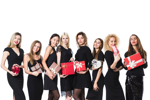 Beautiful happy women with gifts in hands in black dresses. - Foto, afbeelding
