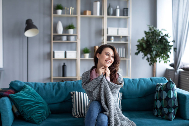 Young beautiful woman relaxing on a cozy sofa at home.  - Foto, afbeelding