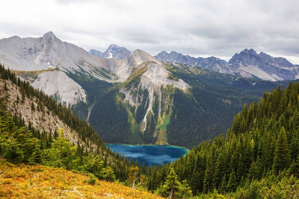 Kanada 'daki dağ gölünün sakin sularındaki kayaların yansımasıyla sakin bir manzara.. - Fotoğraf, Görsel