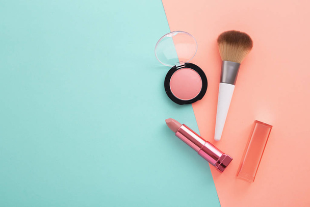 Lipstick, blush and brush on pastel color background - Φωτογραφία, εικόνα