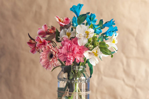 Woman holds up a glass jar of beautiful colorful spring flowers - Photo, Image