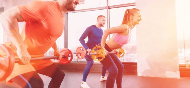 Les gens avec des haltères dans la salle de gym de formation de leurs muscles biceps - Photo, image