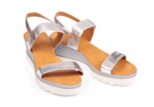Серебряные сандалии обувь для леди на белом фоне
 - Фото, изображение