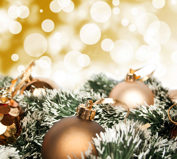 An arrangement of golden Christmas baubles against a festive bok - Fotoğraf, Görsel