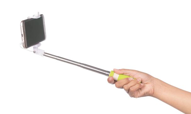 hand holding selfie stick with  mobile phone isolated on a white - Photo, Image