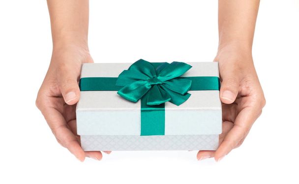 kéz gazdaság egy ajándék színű ezüst doboz zöld szalag és íj i - Fotó, kép