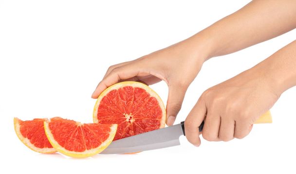 female hands cutting ripe grapefruit isolated on white background.  - Photo, Image