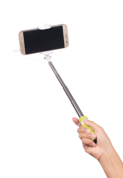 hand houden selfie stick met mobiele telefoon geïsoleerd op een witte - Foto, afbeelding