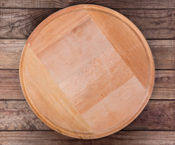 Tavola rotonda vuota per pizza in legno su tavolo rustico, vista dall'alto
 - Foto, immagini