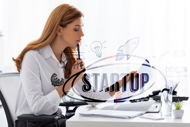 Вид сбоку на предпринимательницу, держащую рядом с документами бумагу с графиками и ноутбук на столе, вверху иллюстрация
 - Фото, изображение
