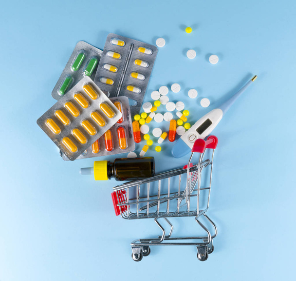 pílulas em um carrinho de criança em um fundo azul - Foto, Imagem
