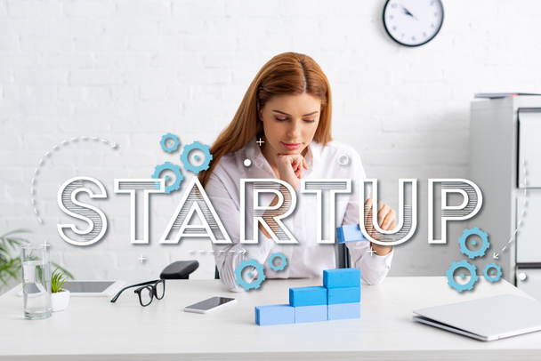 Attractive businesswoman stacking marketing pyramid from blue building blocks on table, startup illustration - Foto, Bild