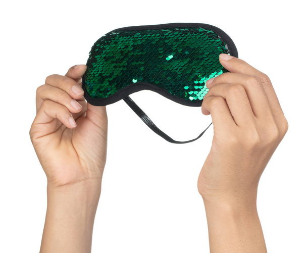 Hand holding Groen slapend oogmasker met pailletten die eruit zien als - Foto, afbeelding