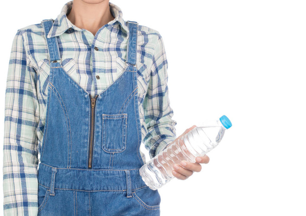 遊んだシャツの若い女性と瓶の水を持っているビブジーンズは - 写真・画像