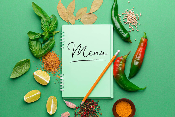  Notebook with word MENU and different spices on color background - Фото, изображение