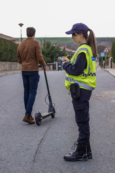 Polis bir çocuğu elektrikli scooterla durdurdu. - Fotoğraf, Görsel