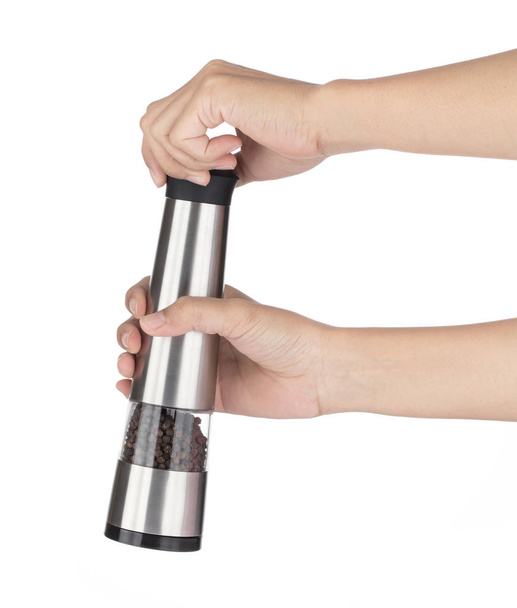 Hand holding stainless steel pepper grinder silver isolated on w - 写真・画像