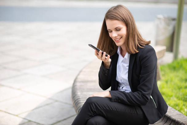 Young happy businesswoman talking on his cellphone's speakerphone - Foto, Imagen
