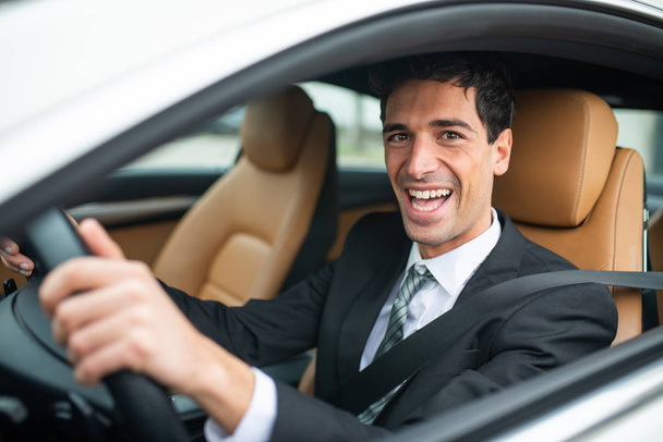 Smiling businessman driving his new white car - Foto, imagen
