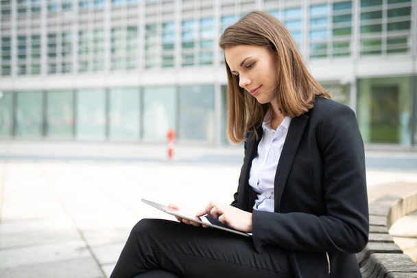 Portrait of a young woman using a tablet in front of her office - Photo, Image