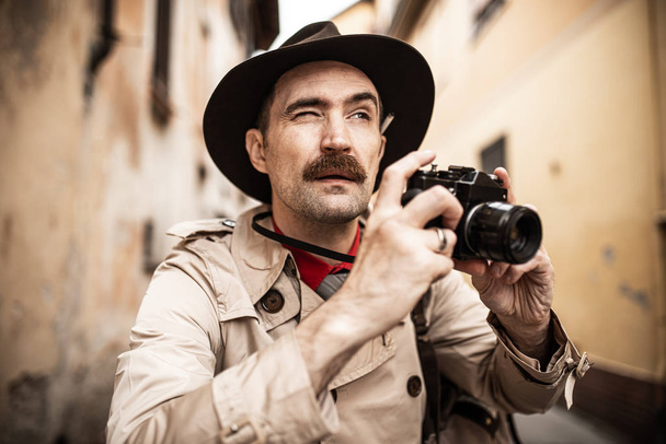 Spy or paparazzo photographer, man using camera in a city street - Фото, зображення