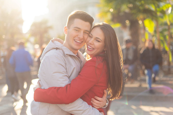 Young couple hugging  in a city street, lens flare - Fotó, kép