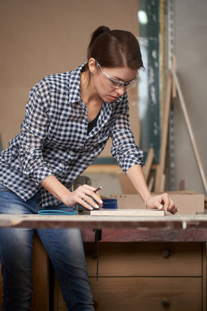 Woman carpenter with tape measure and blackboard - Zdjęcie, obraz