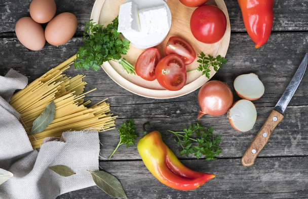 voedselingrediënten - pasta, groenten, eieren op een houten ondergrond - Foto, afbeelding