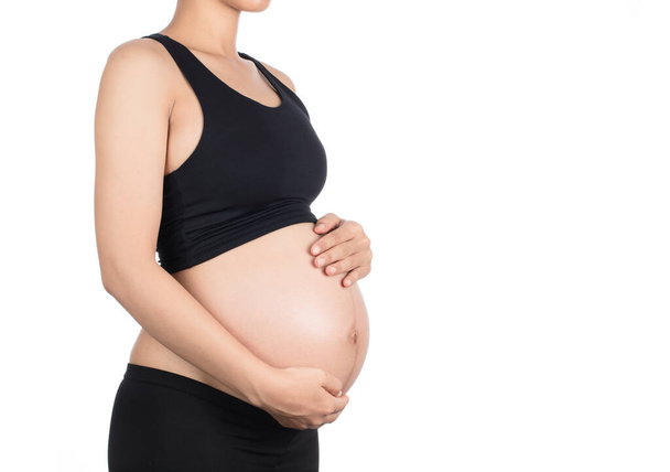 Schwangere Frau in schwarzer Unterwäsche isoliert auf weißem Hintergrund - Foto, Bild