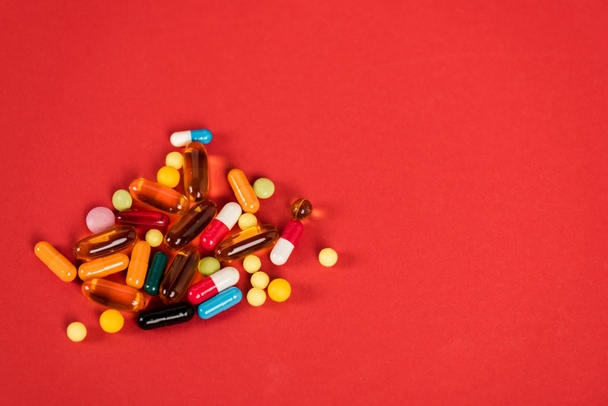 colorful pills on red with copy space  - Zdjęcie, obraz