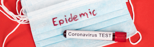 prise de vue panoramique de l'échantillon avec test de coronavirus près de masques médicaux de protection avec lettrage épidémique sur rouge
  - Photo, image