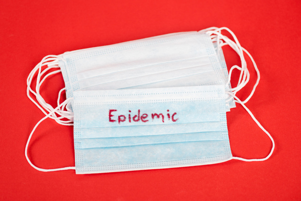 górny widok masek medycznych z epidemiologicznym napisem na czerwono  - Zdjęcie, obraz