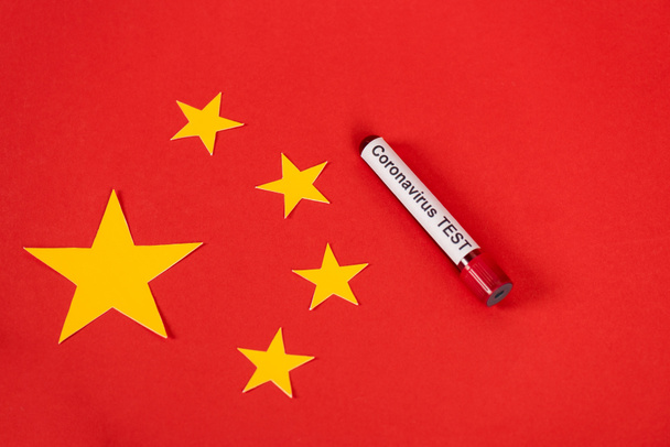 a minta tetejére néző, vörös kínai zászló melletti, koronavírus-vizsgálattal ellátott betűkkel  - Fotó, kép
