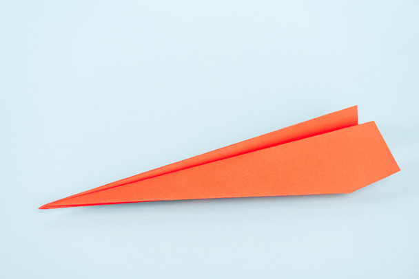 oranje papieren vliegtuig op blauw met kopieerruimte  - Foto, afbeelding