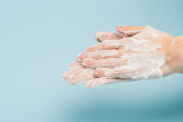 oříznutý pohled na muže myjící ruce na modré  - Fotografie, Obrázek