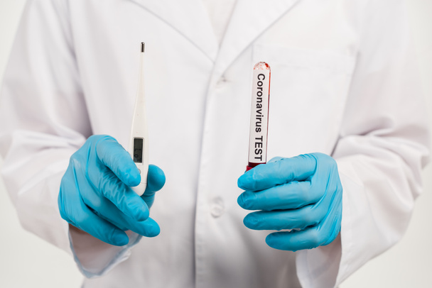 vue recadrée d'un scientifique tenant un échantillon avec lettrage test coronavirus et thermomètre numérique isolé sur blanc
  - Photo, image