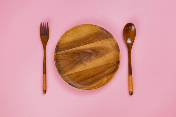 Közelkép a fából készült edény kanál és villa rózsaszín háttér - Fotó, kép