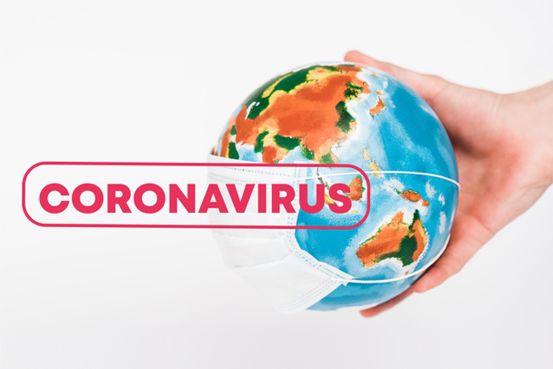 Beyaz harflerle Coronavirus 'un yanında kürenin koruyucu maskesini tutan adamın görüntüsü.  - Fotoğraf, Görsel