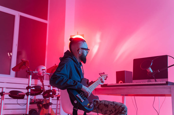 Müzik ve kayıt stüdyosu konsepti yaratmak - Sakallı komik adam gitaristi ev stüdyosunda elektro gitar kaydı yapıyor - Fotoğraf, Görsel